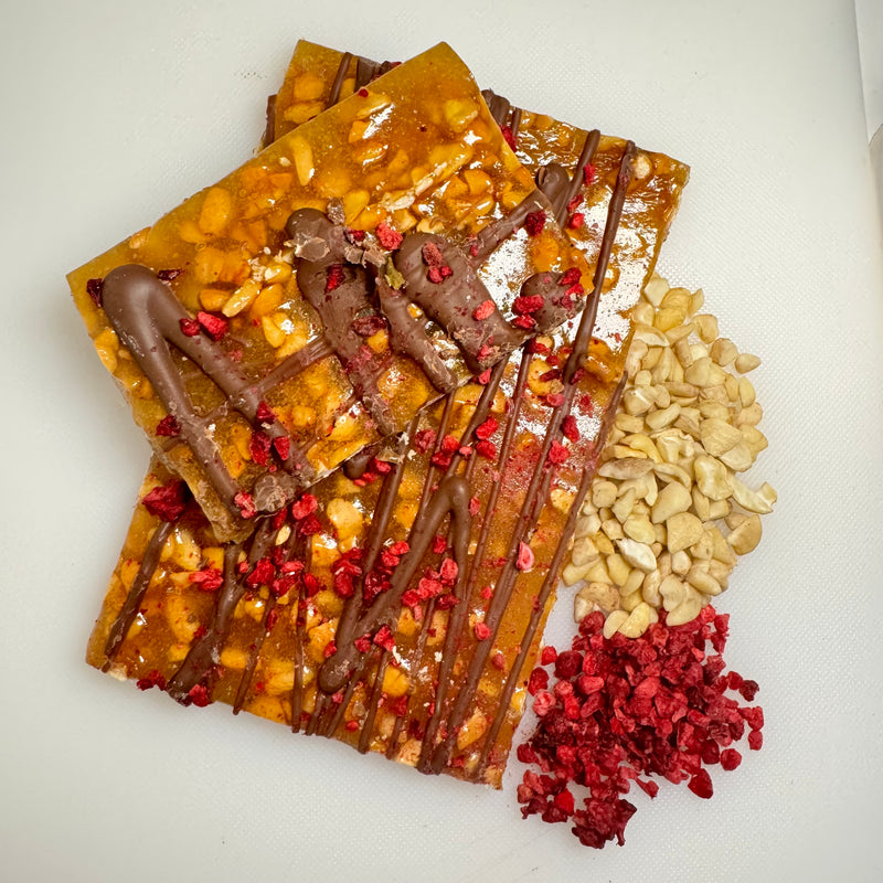 Cashew Brittle with freeze-dried raspberries and a drizzle of creamy milk chocolate